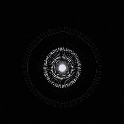 The primary subject of the image is a circular object with a pattern of lines on it. The setting is a black background, which creates a contrast with the circular object. The visual style appears to be a combination of a photo and a digital art or illustration, as the circular object has a distinct pattern and the background is black. The colors and mood of the image are predominantly dark, with the circular object being the main focus and the background serving as a contrasting element.